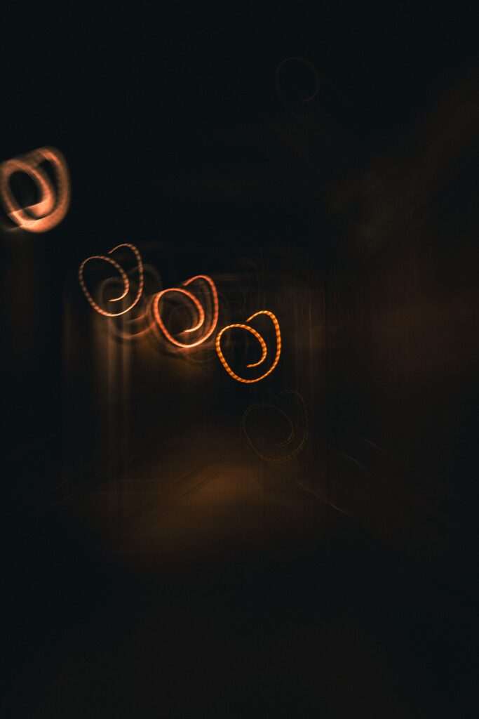 Photo abstraite d’une source lumineuse tourbillonnante, capturée avec des jeux de vitesse d’obturation. Image artistique mettant en avant les mouvements et les effets de lumière créés par l’appareil photo.