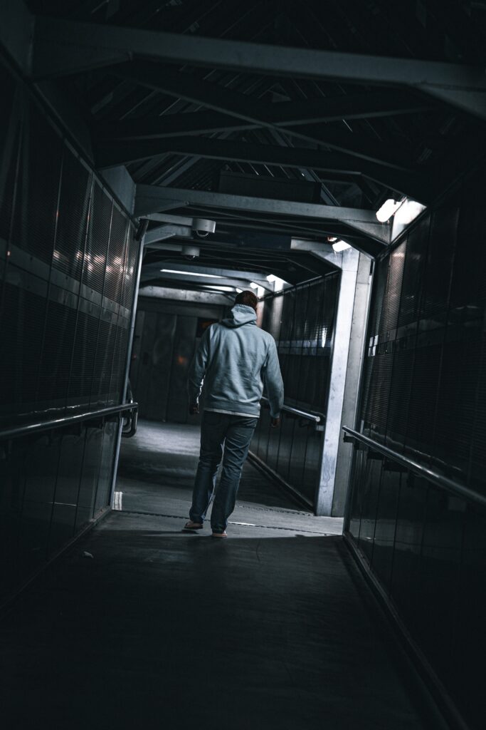 Jeune homme de dos lors d’un shooting privé à Saint-Étienne, créant une ambiance cinématographique. Portrait artistique avec une lumière dramatique, capturant l’atmosphère mystérieuse et inspirée du cinéma.